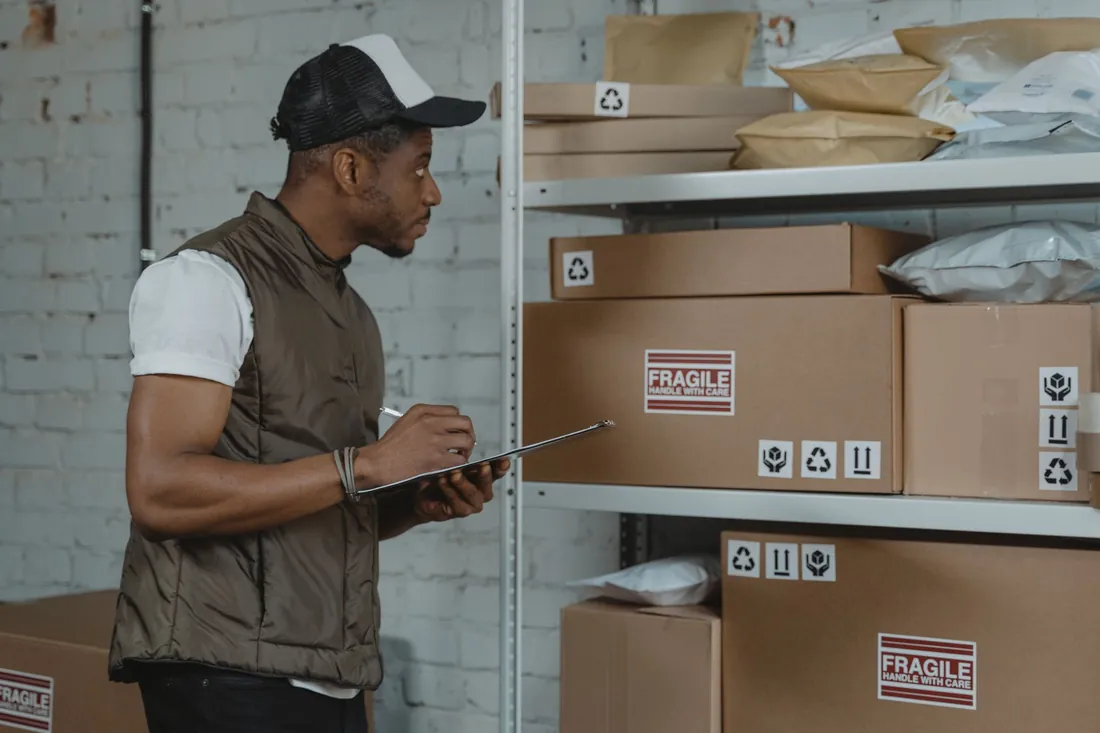 Warehouse worker checking parcels on shelves before dispatch